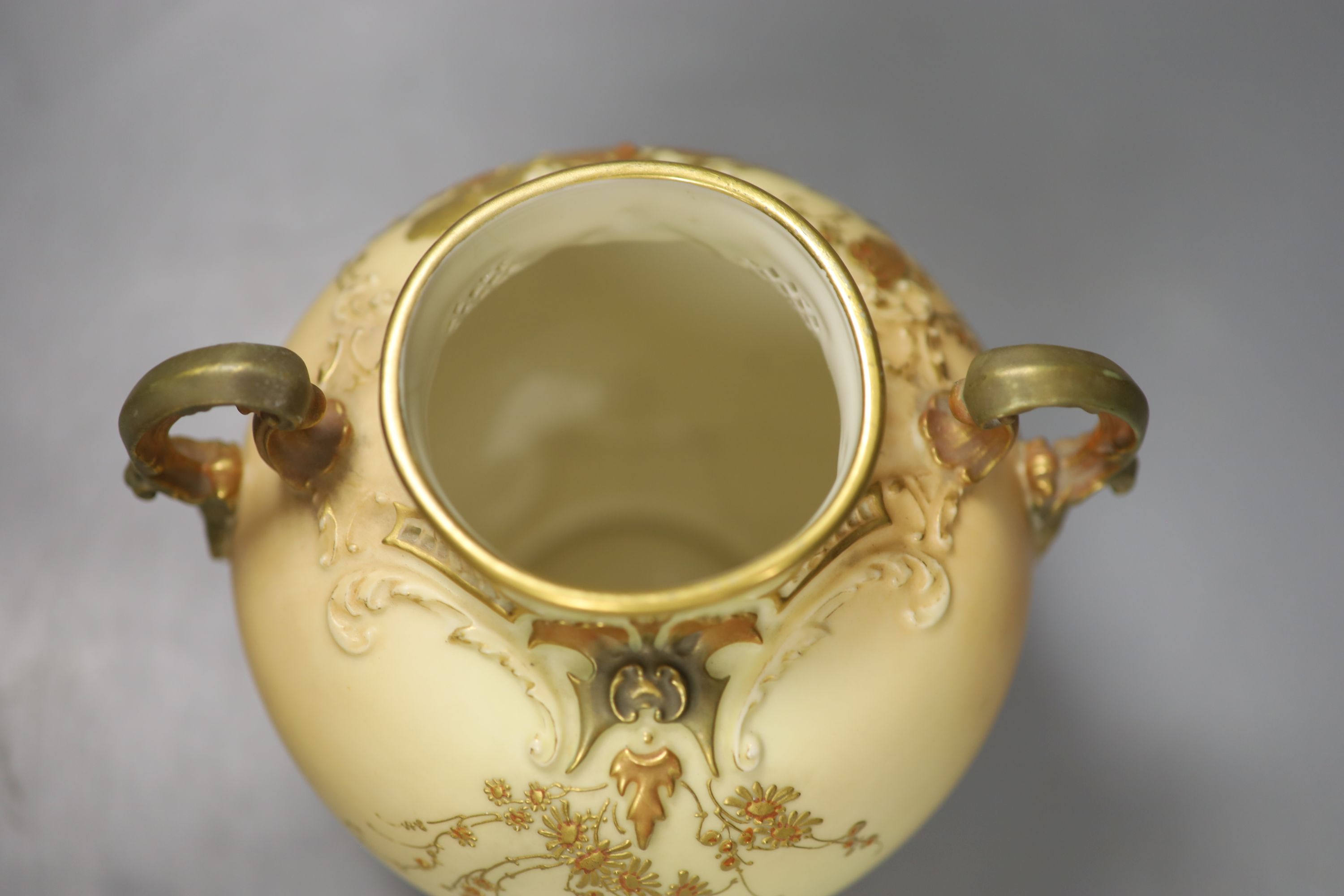 A Royal Worcester two handled ovoid vase moulded and gilded with flowers on a blush ivory ground, shape 1515 date code for 1896, 20cm h